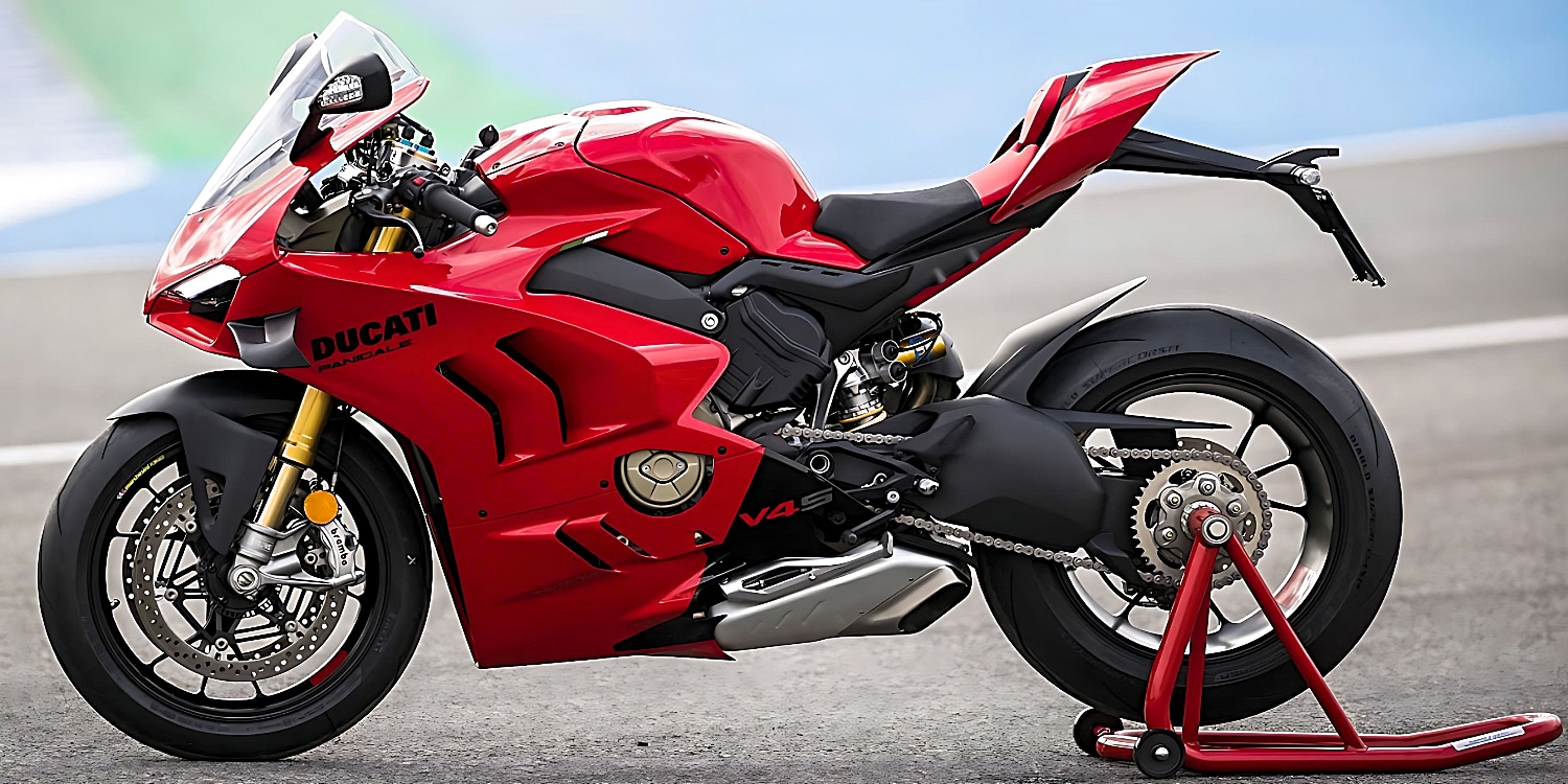 The 2023 Ducati Panigale V4 S motorcycle in red and black, securely parked on a racing track stand with its back wheel off the ground.