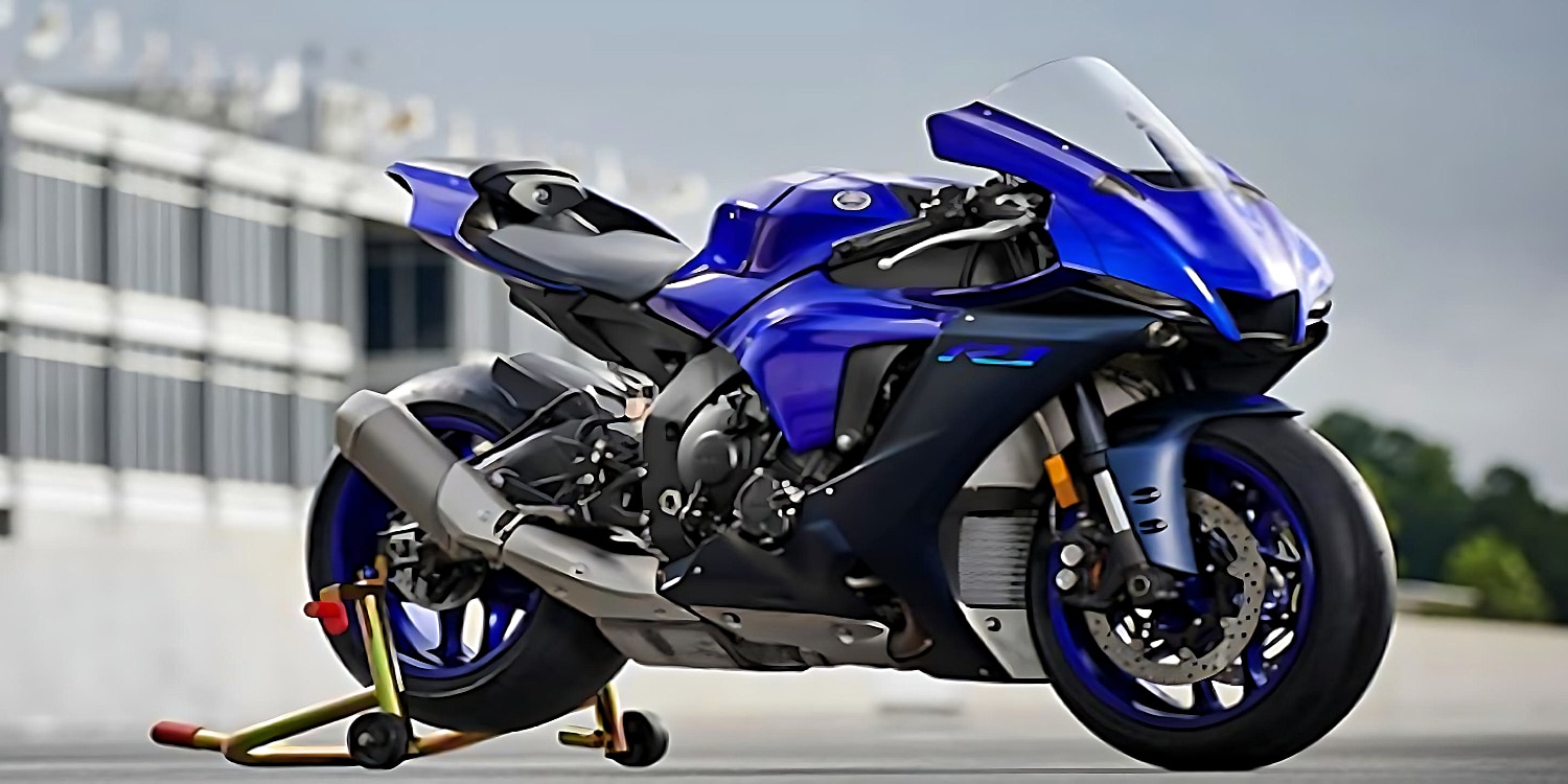 The 2023 Yamaha YZF-R1M motorcycle in all-blue is displayed on a brass racing track stand with elevated back wheel. Designed for performance, it boasts advanced technology, aerodynamics, powerful engine, optimized suspension, and cutting-edge electronics for top-notch speed and handling. Perfect for racers and motorcycle enthusiasts.