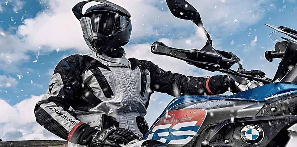 A rider with a helmet on a BMW R1100 motorcycle pauses to enjoy the scenery on a chilly evening after a heart-pumping ride. But riding a motorcycle during cold weather can be a challenge and potentially dangerous experience if you are not properly dressed.