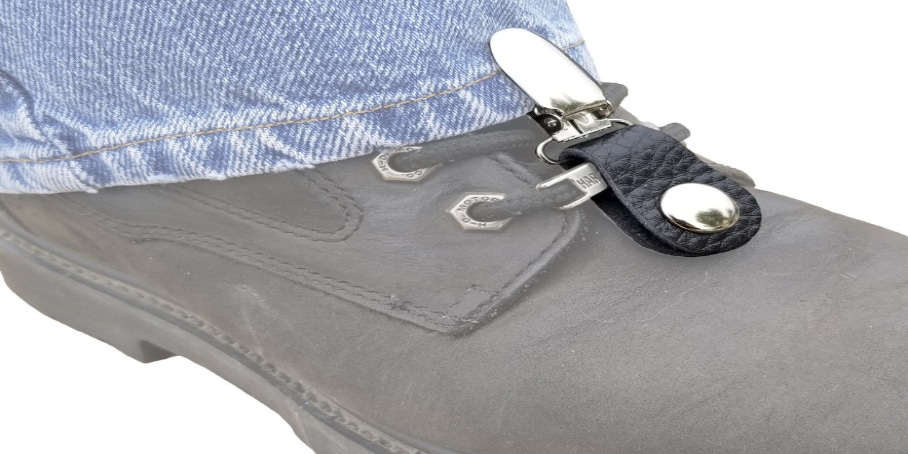 A cowhide leather strap forms a boot loop that securely clips the pants cuff, while the other end snaps onto the laces for added security
