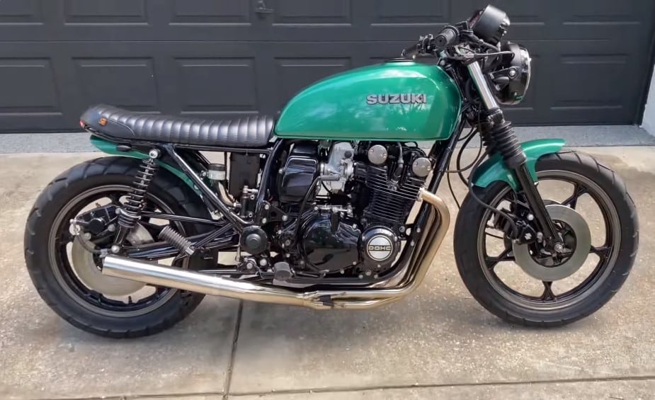 A side profile of “Suzie” the Suzuki GS850 Cafe Racer showing those lovely cafe racer lines with a flat bench lined up with the steering heads and arching tank plus hear bum-stop. Notice how low the main mass of the bike is slung to keep its shiny side up through turns at speed.